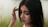 a woman with long black hair holding her hand to her head