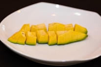 Fresh mango cubes neatly packed in transparent containers with icy blue accents.