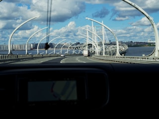 A completed highway with vehicles and a bridge in the background.