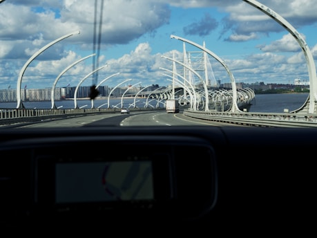 A completed highway with vehicles and a bridge in the background.