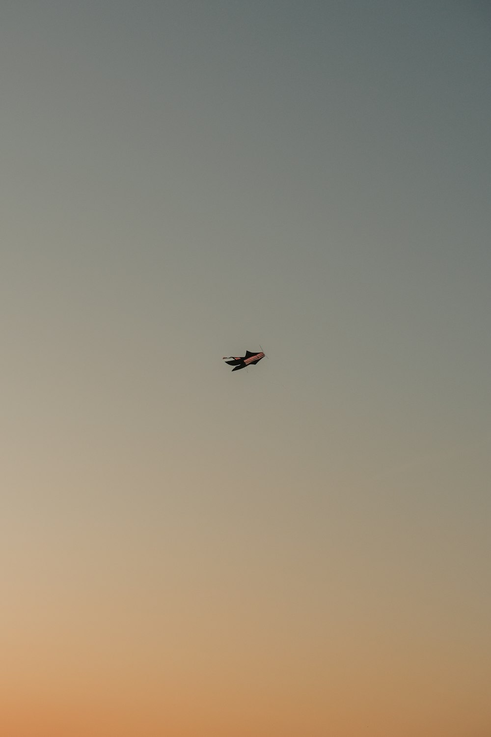 an airplane is flying in the sky at sunset