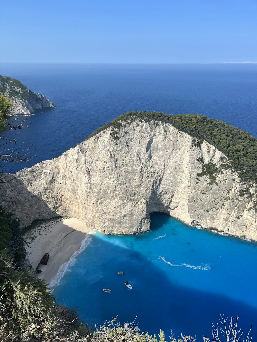 Un grande specchio d'acqua blu accanto a una scogliera