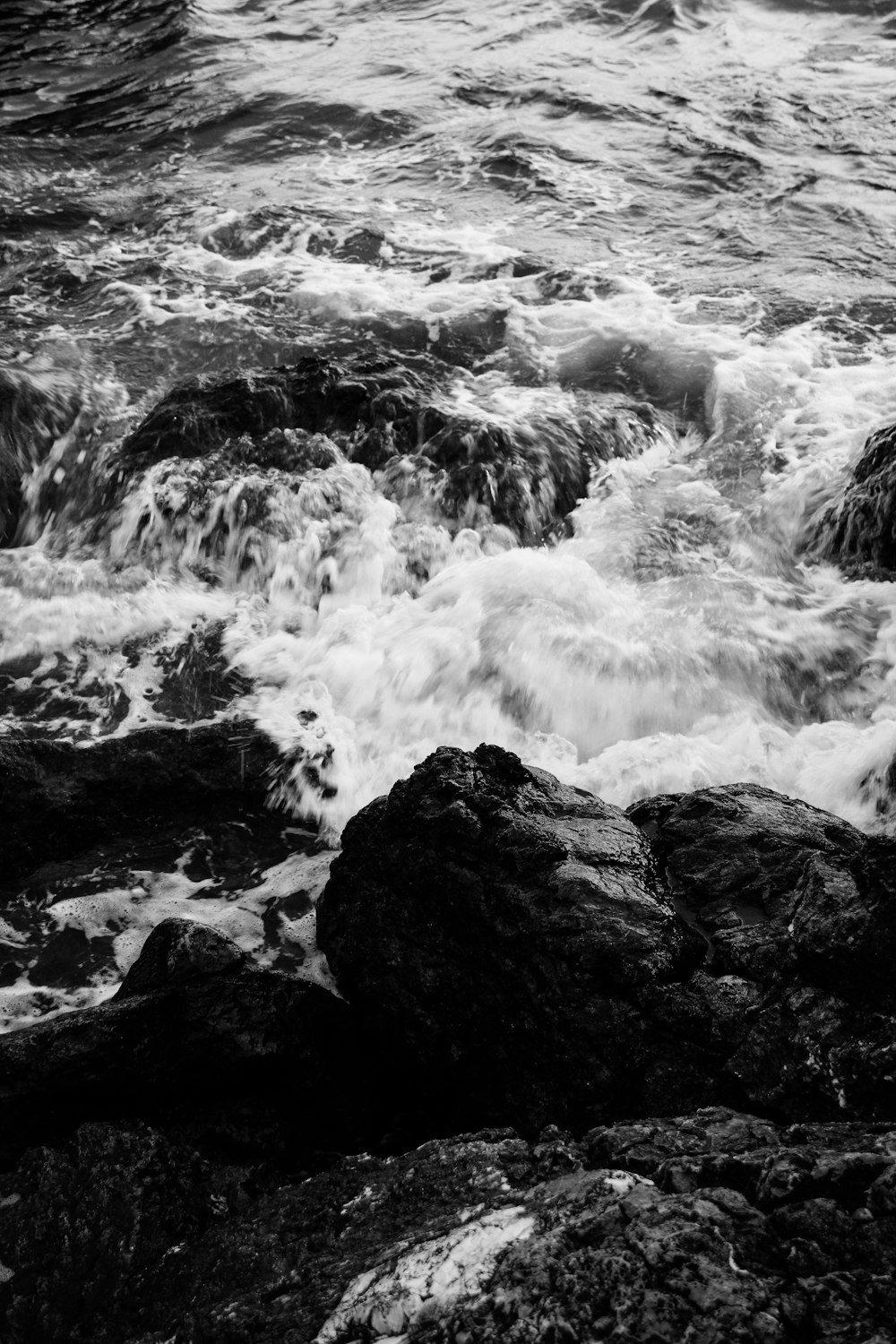 a black and white photo of water and rocks