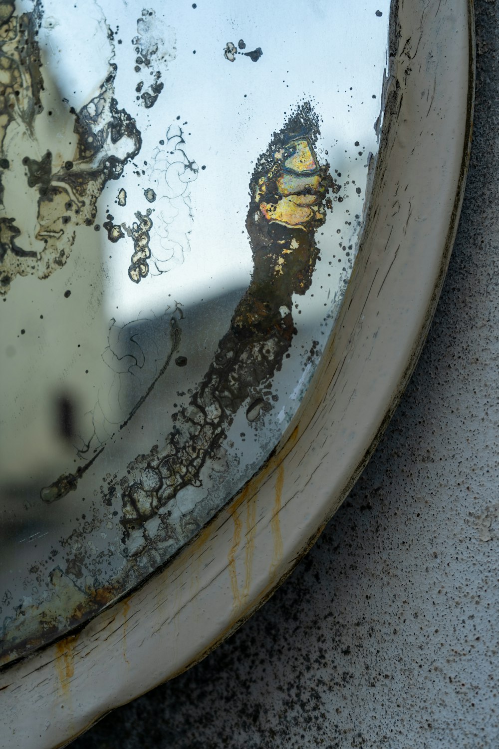 a close up of a dirty mirror on a wall