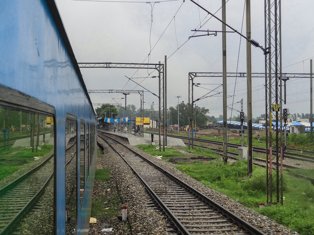 a train traveling down train tracks next to a lush green field