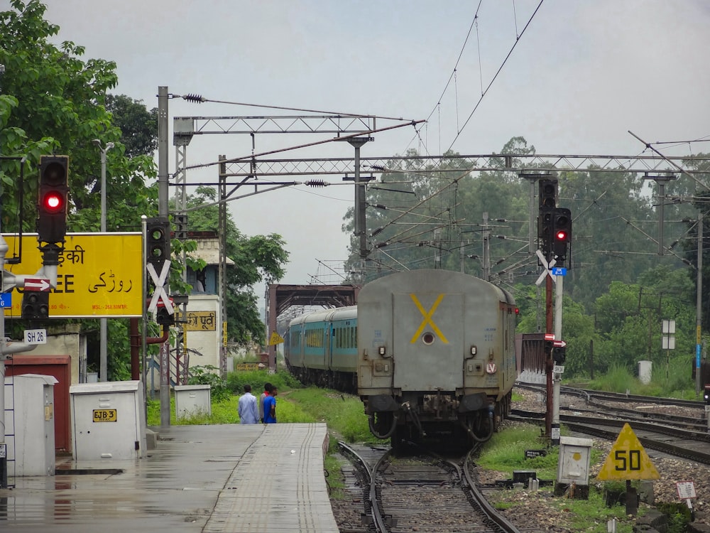 a train traveling down train tracks next to a forest