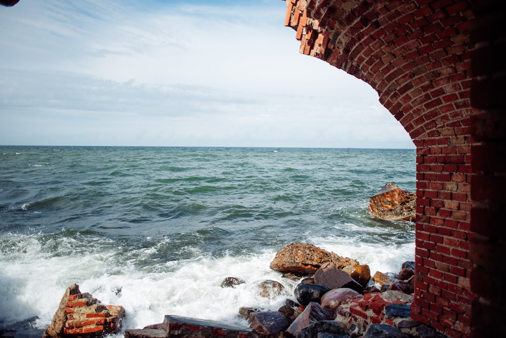 a view of the ocean from a brick wall