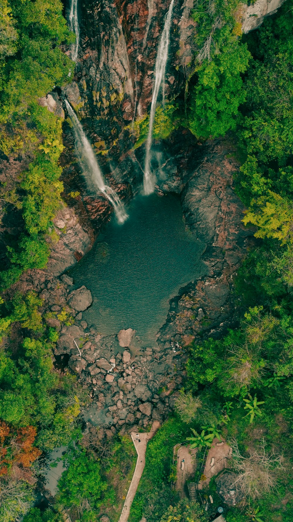 an aerial view of a waterfall in the jungle