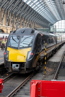 A sleek black van parked outside a modern train station in the Weppes region.