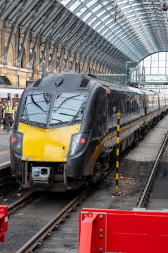 a yellow and black train pulling into a train station