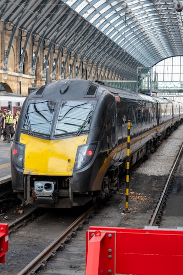 A sleek black van parked outside a modern train station in the Weppes region.