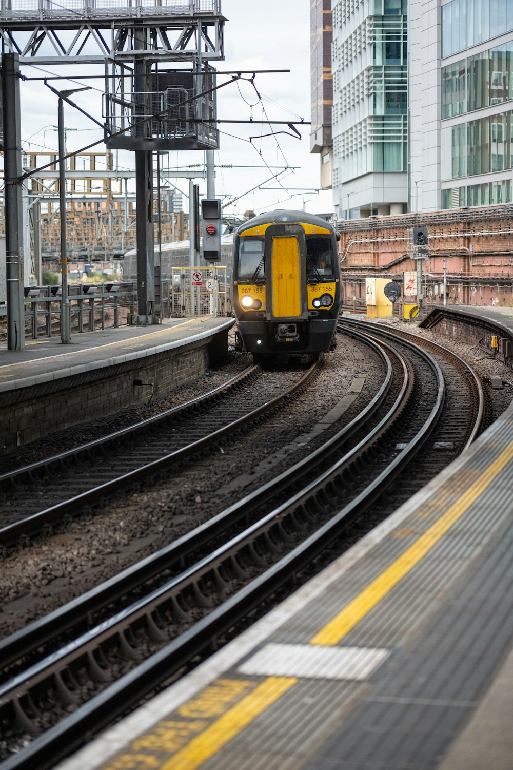 a yellow and black train traveling down train tracks