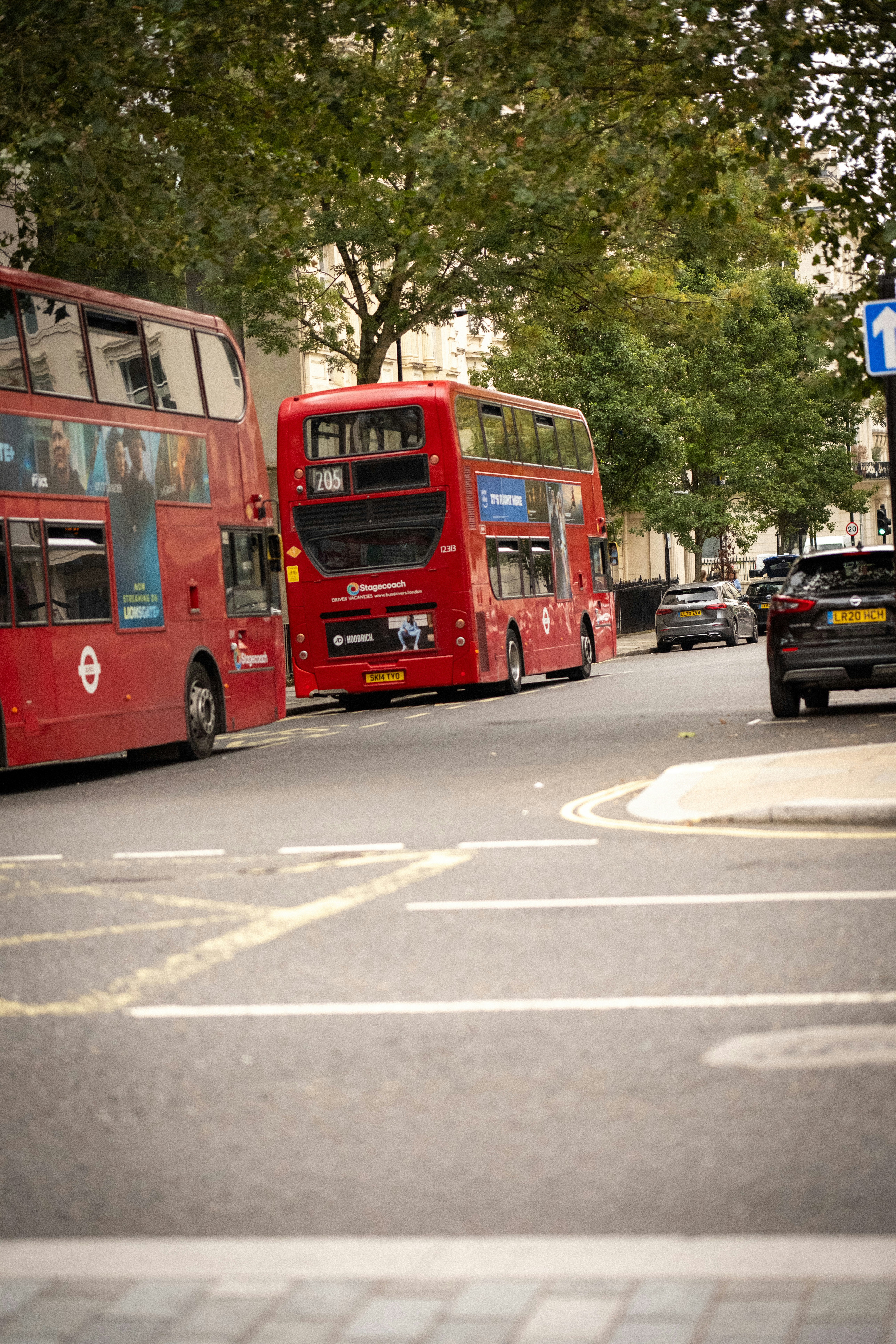 a couple of red double decker buses driving down a street