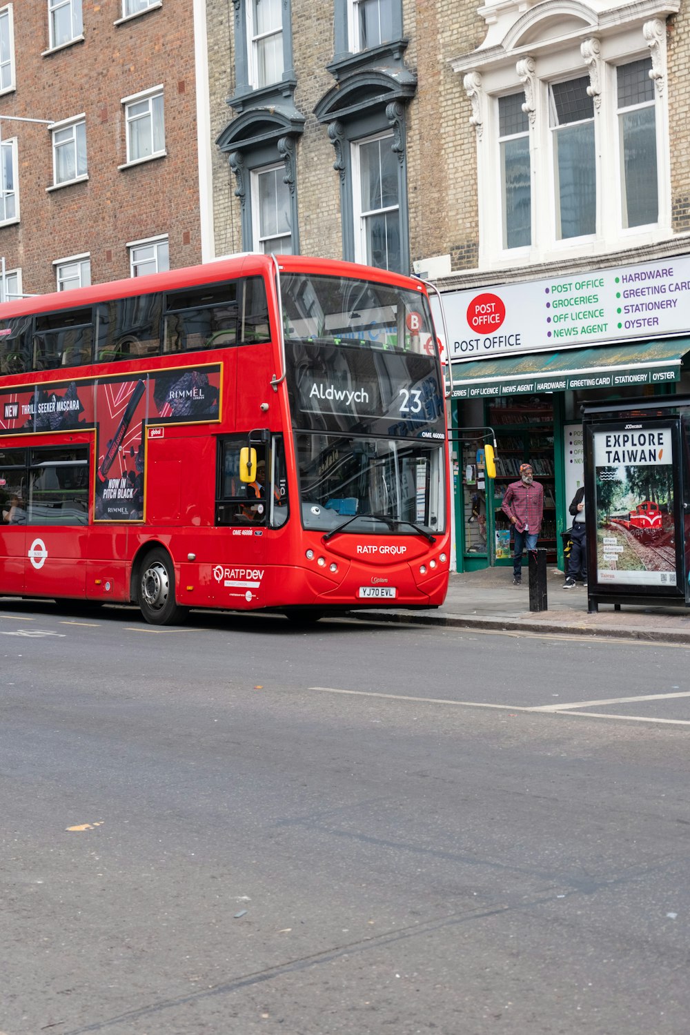 a red double decker bus driving down a street