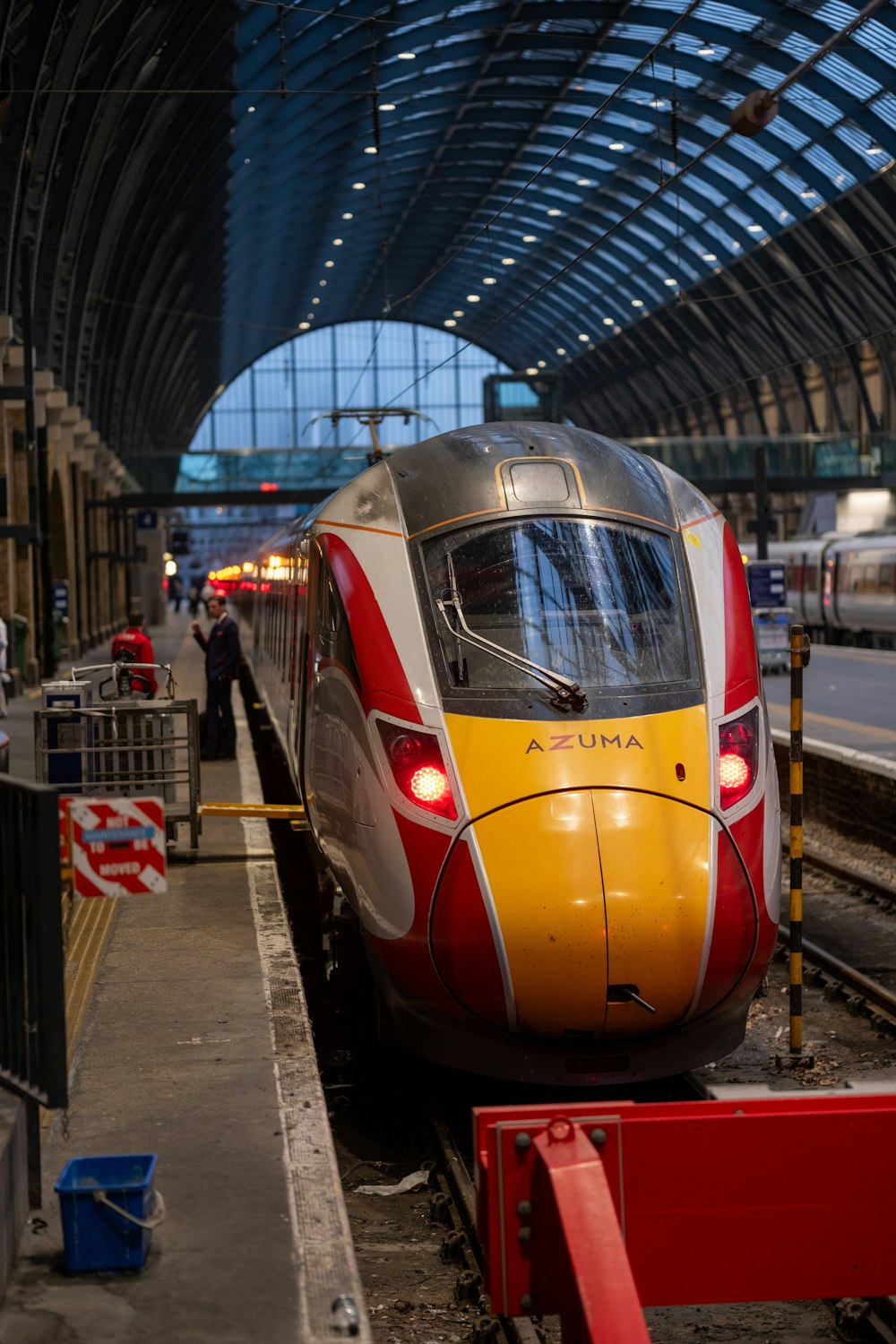 a yellow and red train pulling into a train station