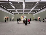 A collection of abstract paintings displayed in a bright gallery space.