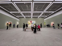 Minimalist gallery space with soft lighting highlighting abstract paintings on white walls.