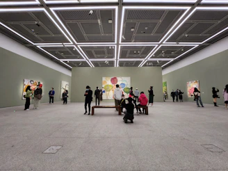 A vibrant gallery wall showcasing colorful paintings in a modern minimalist setting.