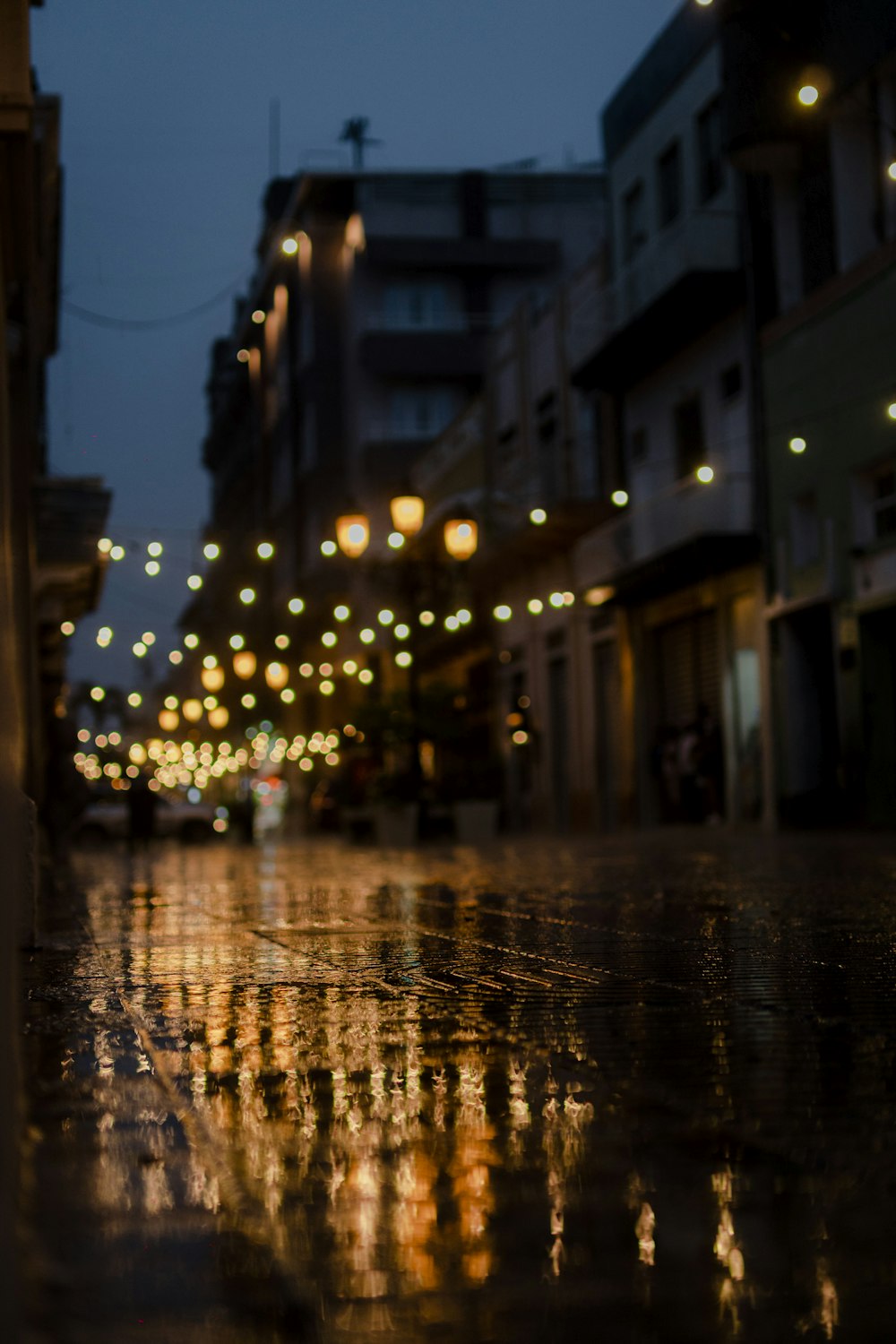 a city street at night with lights reflecting off the wet pavement