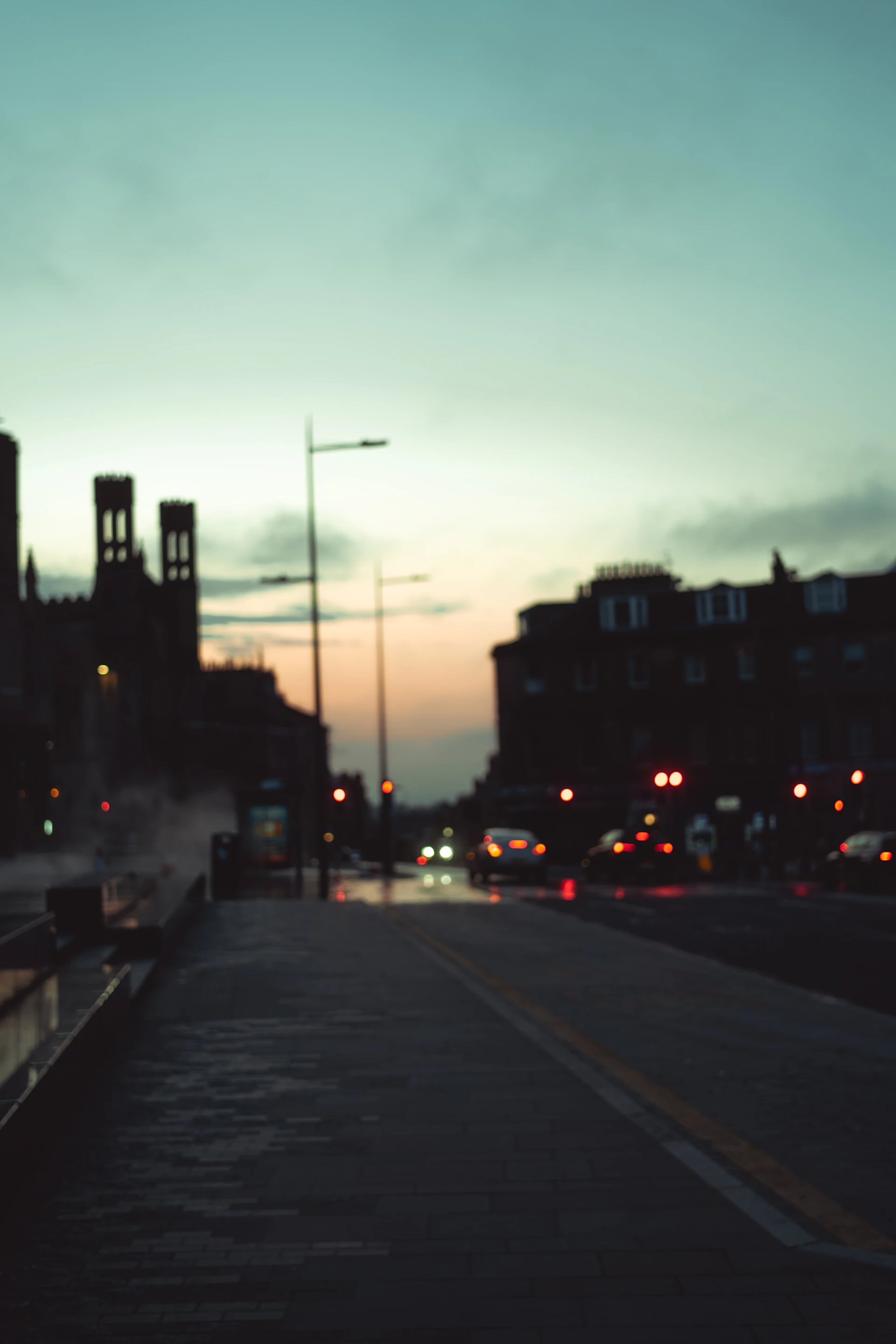 An urban street scene at dusk, with soft lights glowing from windows and subtle shadows on the pavement.