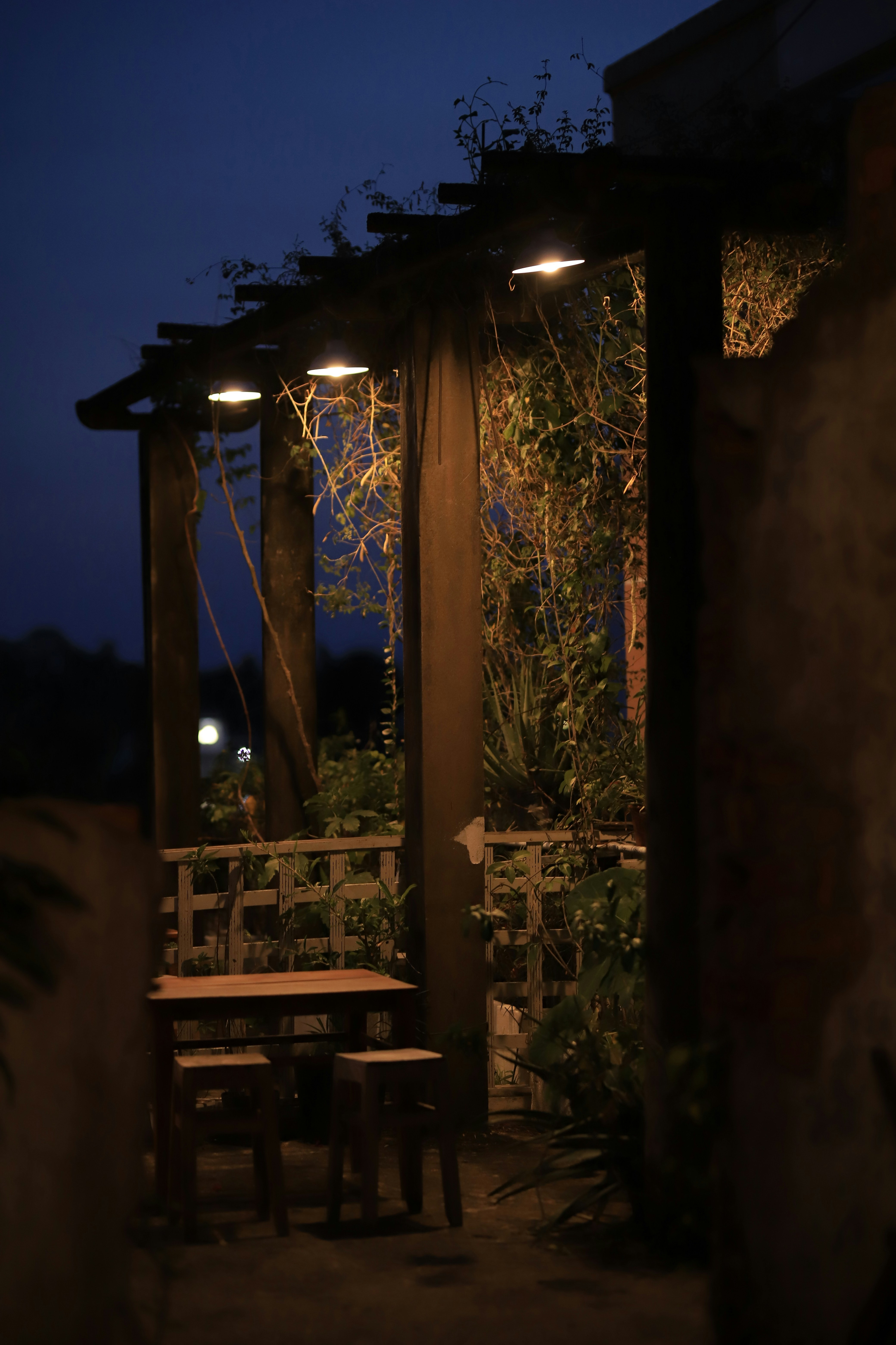 a wooden table sitting under a pergolated roof