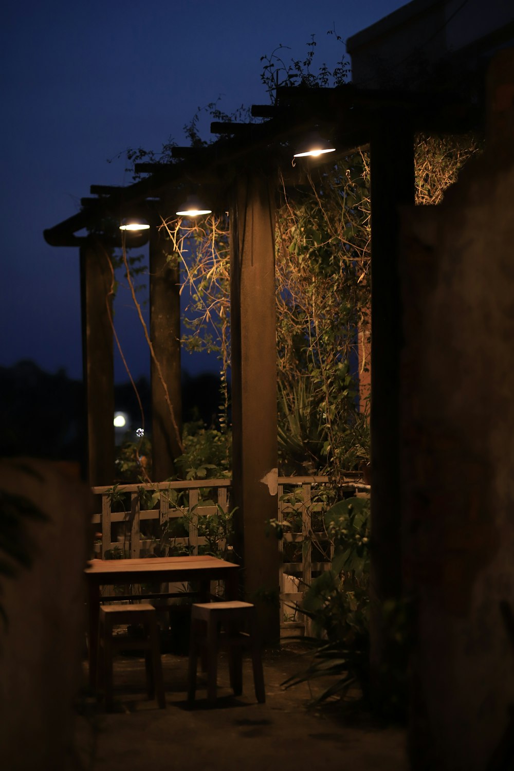 a wooden table sitting under a pergolated roof