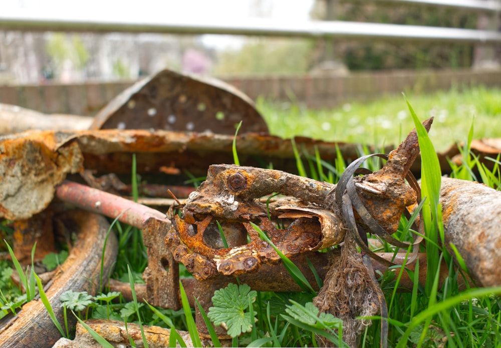 a pile of old rusted metal objects sitting in the grass