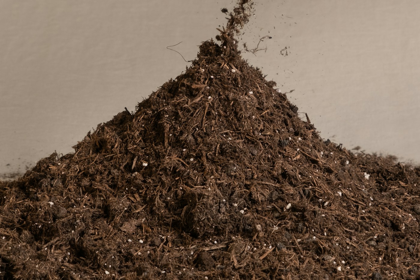 Hand reaching into a pile of finished compost