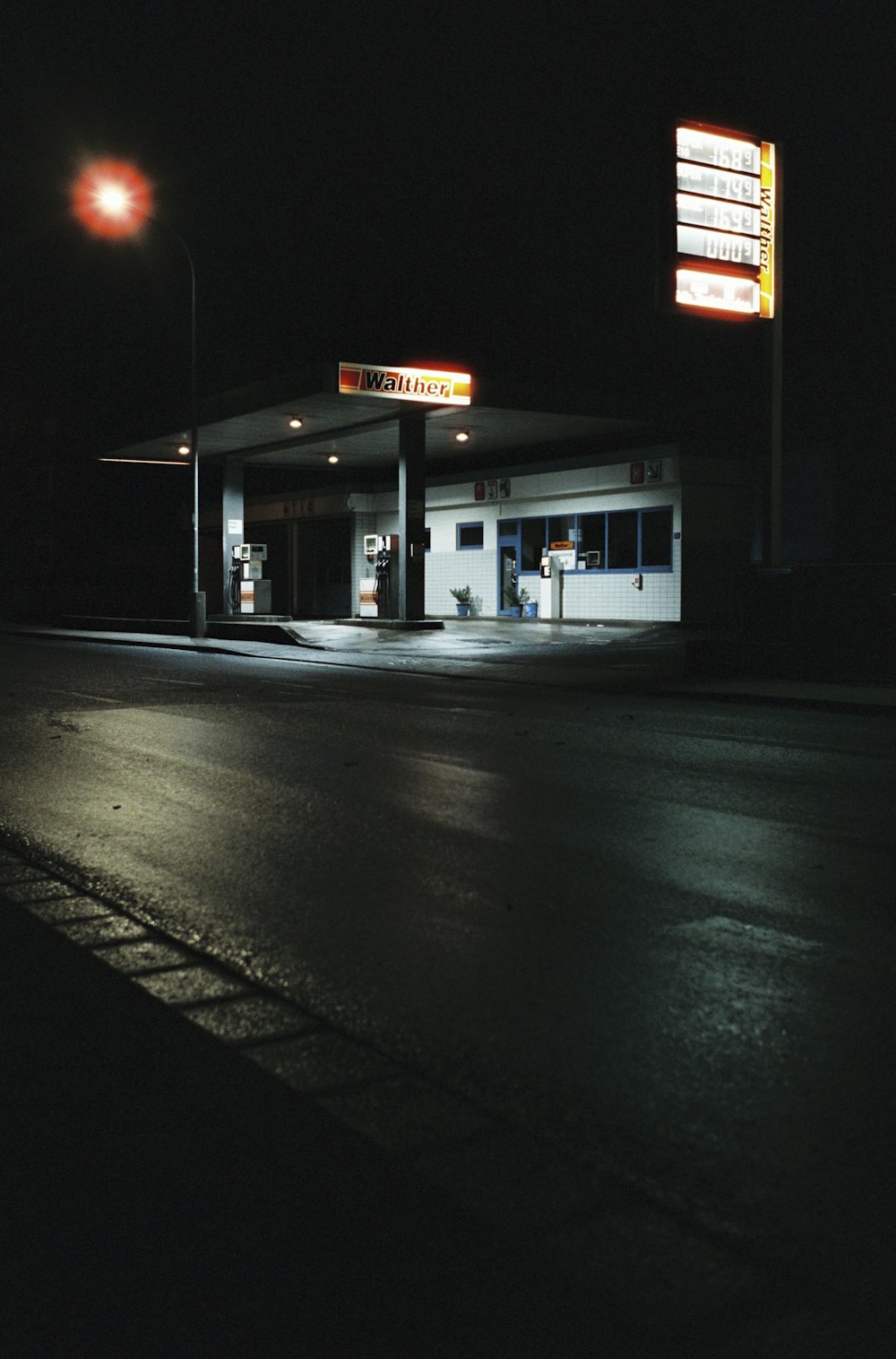 ライトアップされた看板のある夜のガソリンスタンド