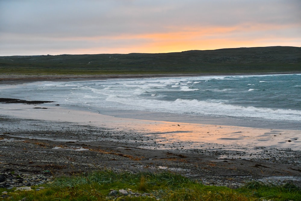 Le soleil se couche sur l’eau à la plage