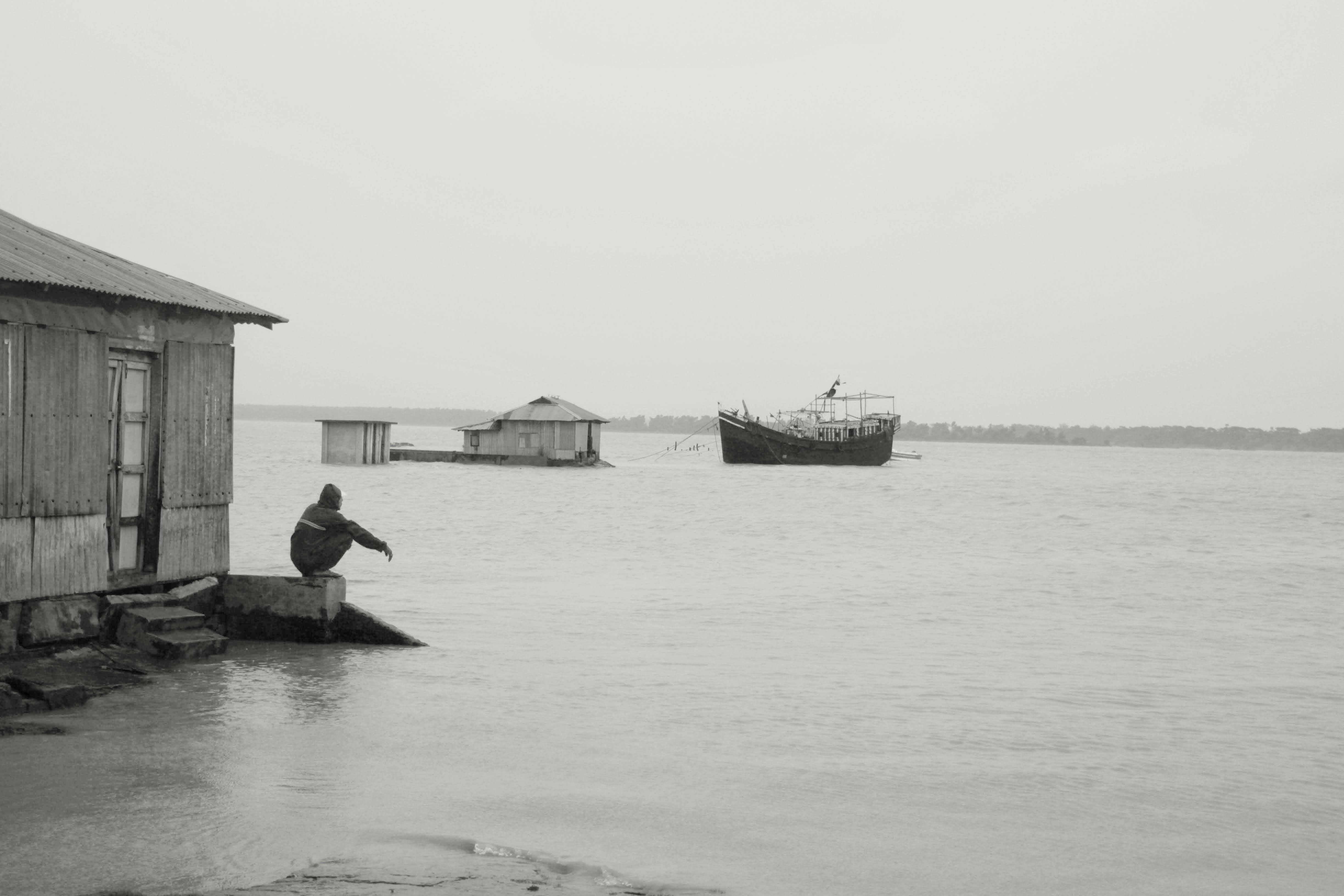 a black and white photo of a person on a dock