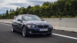 BMW F30 driving smoothly along a highway with the Tricity skyline in the background.