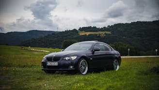 A sleek car parked near Detling Aerodrome Estate with green fields in the background on a sunny day.