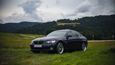A sleek car parked near Detling Aerodrome Estate with green fields in the background on a sunny day.