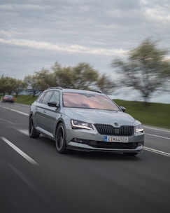 Sleek metallic truck speeding along a futuristic highway under a silver sky.