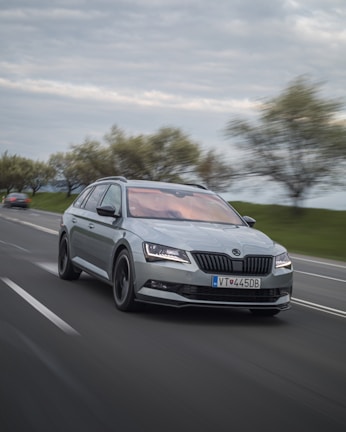 A dynamic shot of a concept car speeding along a coastal highway at sunset.