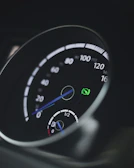 Close-up of a hybrid car dashboard with eco-friendly indicators lit up.