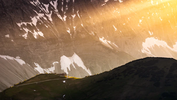 Sunrise casting golden light over the rugged peaks surrounding the alpine cottages at šlaitas 6191.