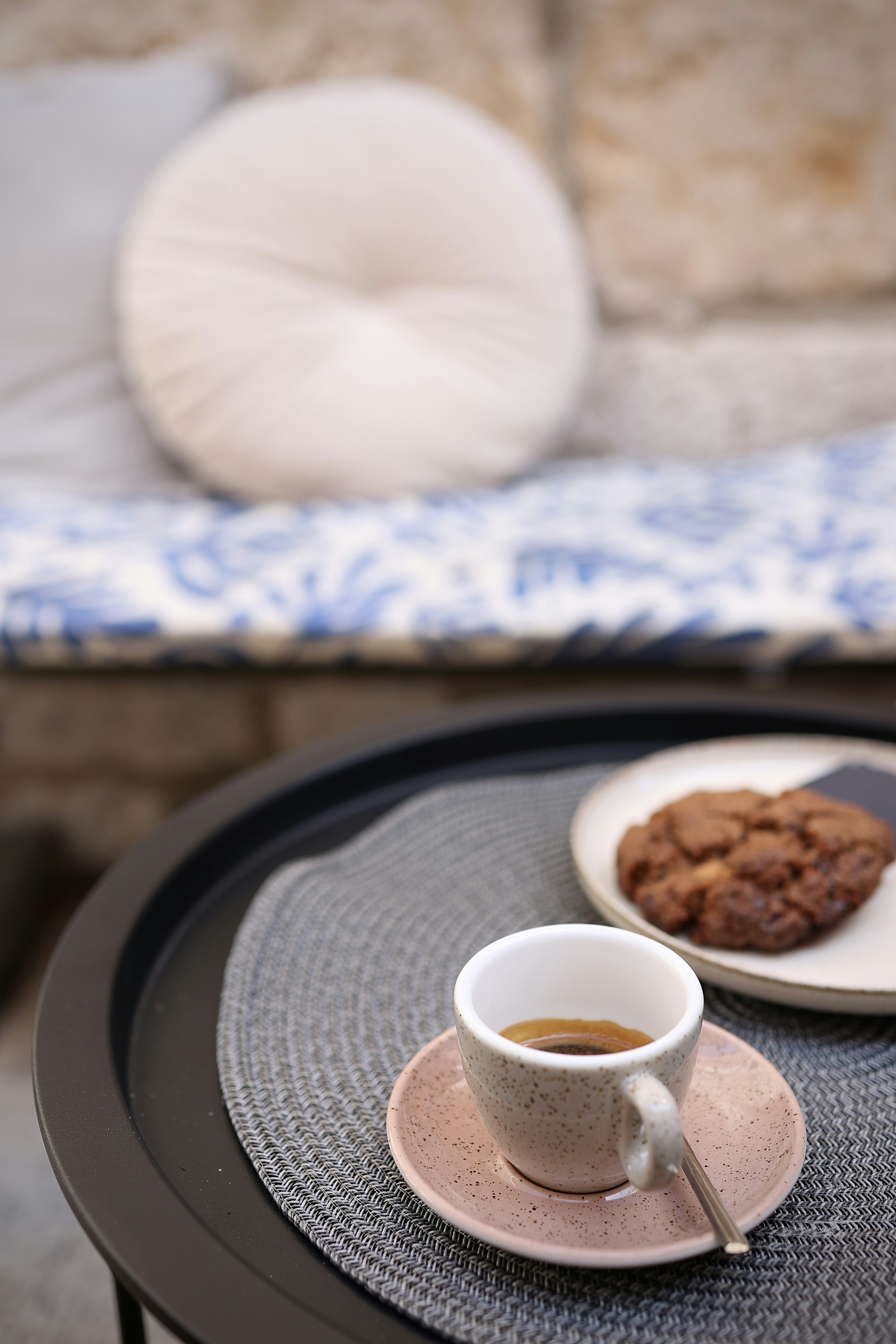 Un tavolo con un piatto di biscotti e una tazza di caffè