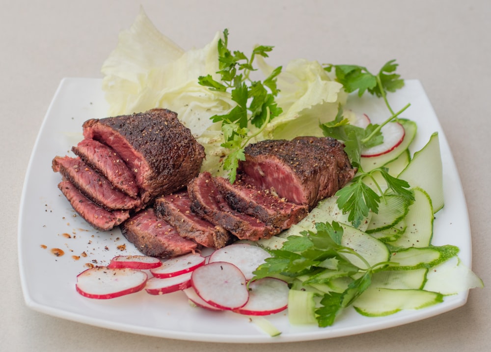 a white plate topped with meat and veggies