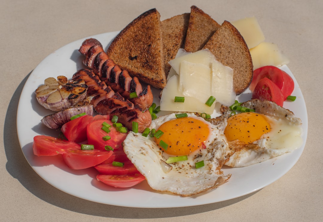 a white plate topped with eggs, toast, tomatoes and meat