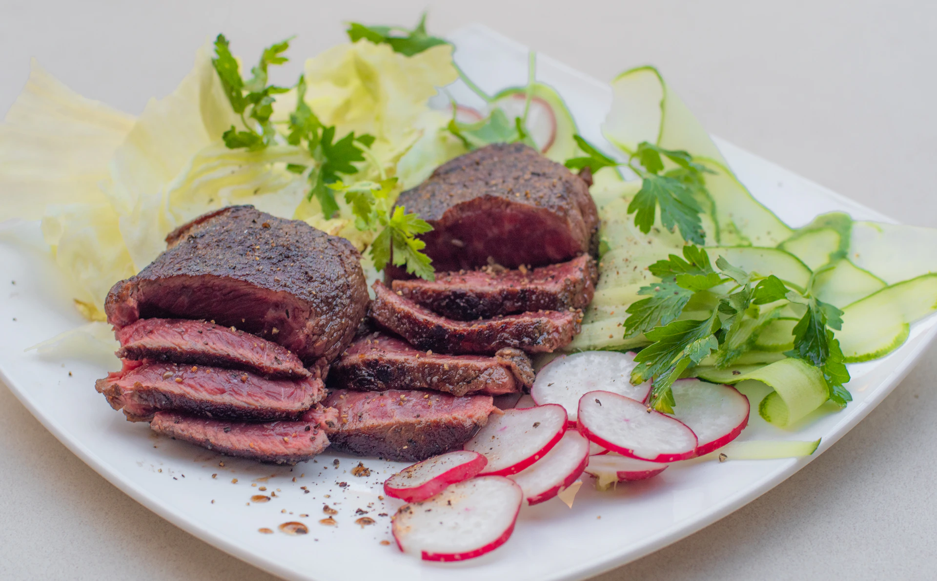 An elegant plate featuring a juicy Wagyu steak sliced to reveal its tender, pink interior, accompanied by roasted vegetables.
