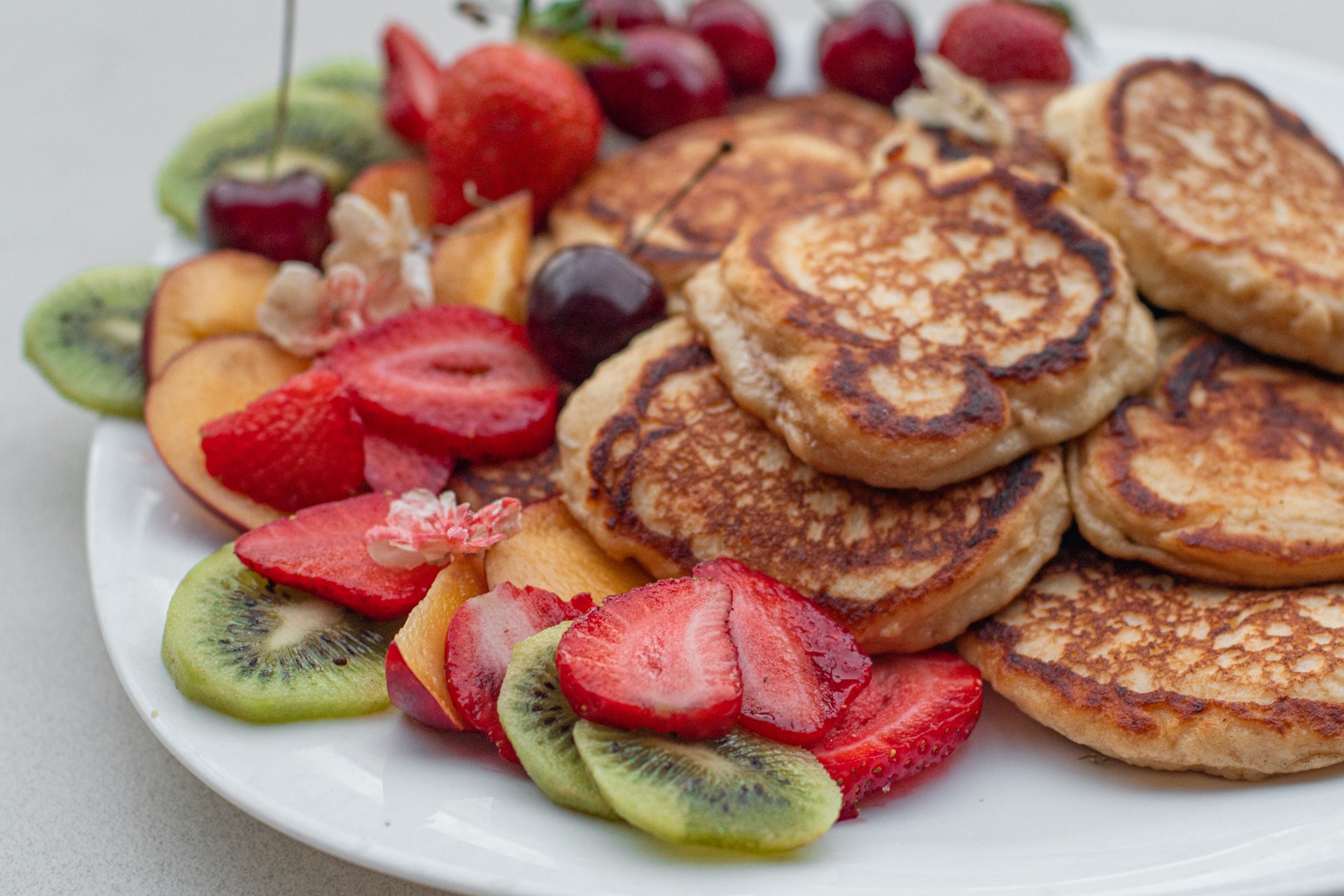 a white plate topped with pancakes and fruit