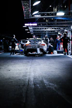 Technician replacing a car battery at night on a busy Dubai street