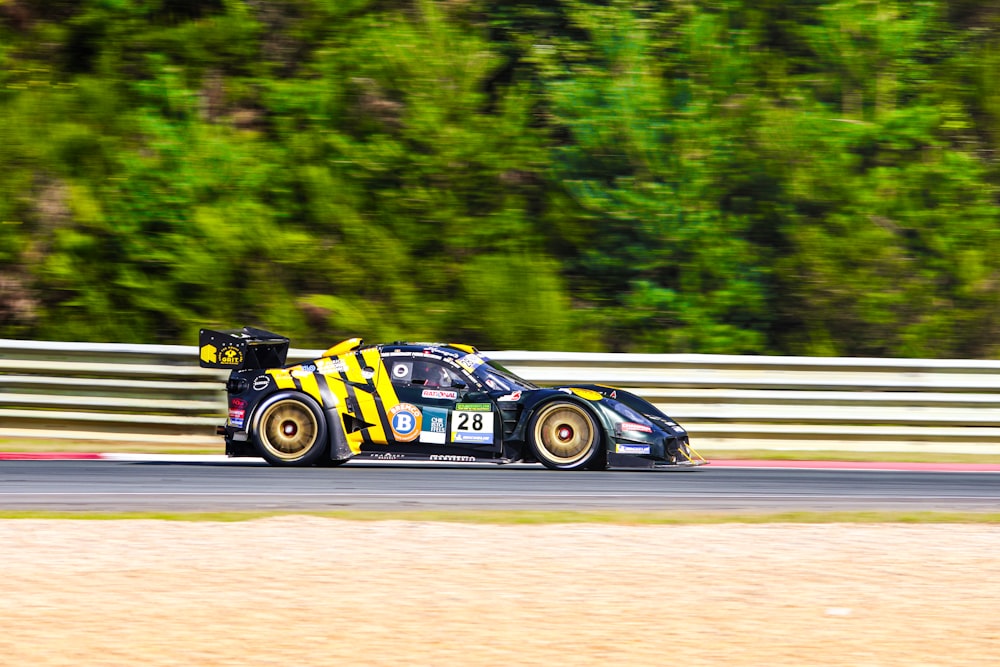 a car driving on a race track with trees in the background