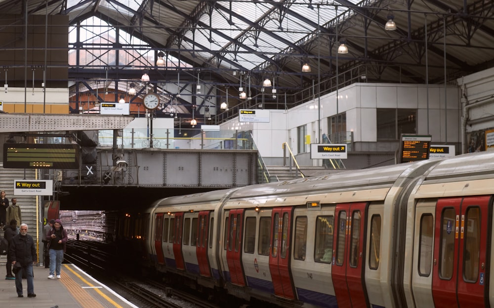 Un tren que se detiene en una estación de tren junto a una plataforma