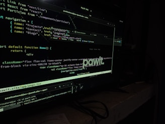 A computer screen displaying code in a dark-themed text editor. The code appears to be written in JavaScript, featuring functions and navigation links. There are file paths and command line interface windows open. A dark environment enhances the glow of the screen.