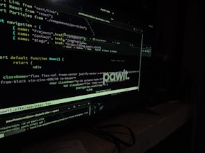 A computer screen displaying code in a dark-themed text editor. The code appears to be written in JavaScript, featuring functions and navigation links. There are file paths and command line interface windows open. A dark environment enhances the glow of the screen.