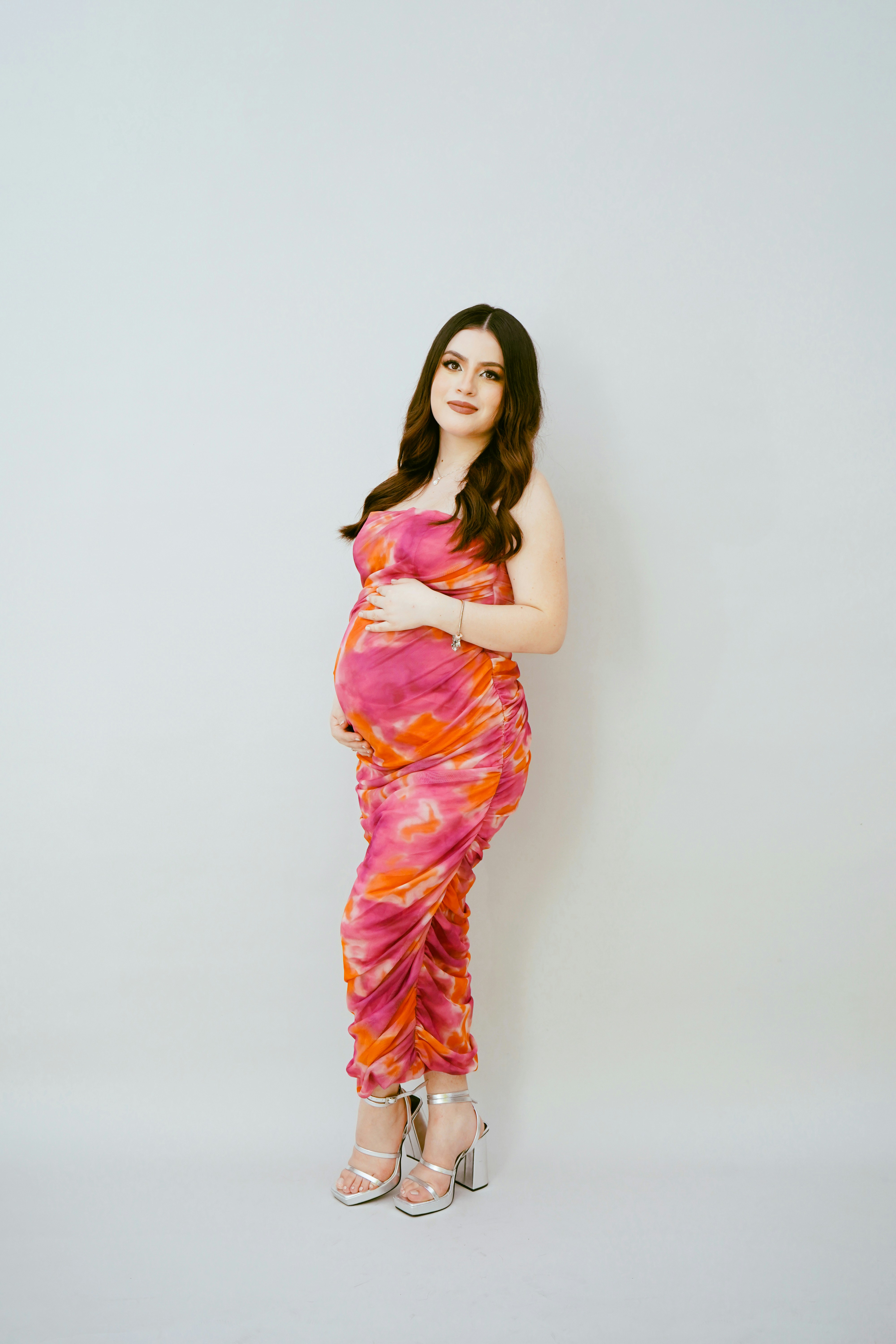 a pregnant woman in a pink and orange dress