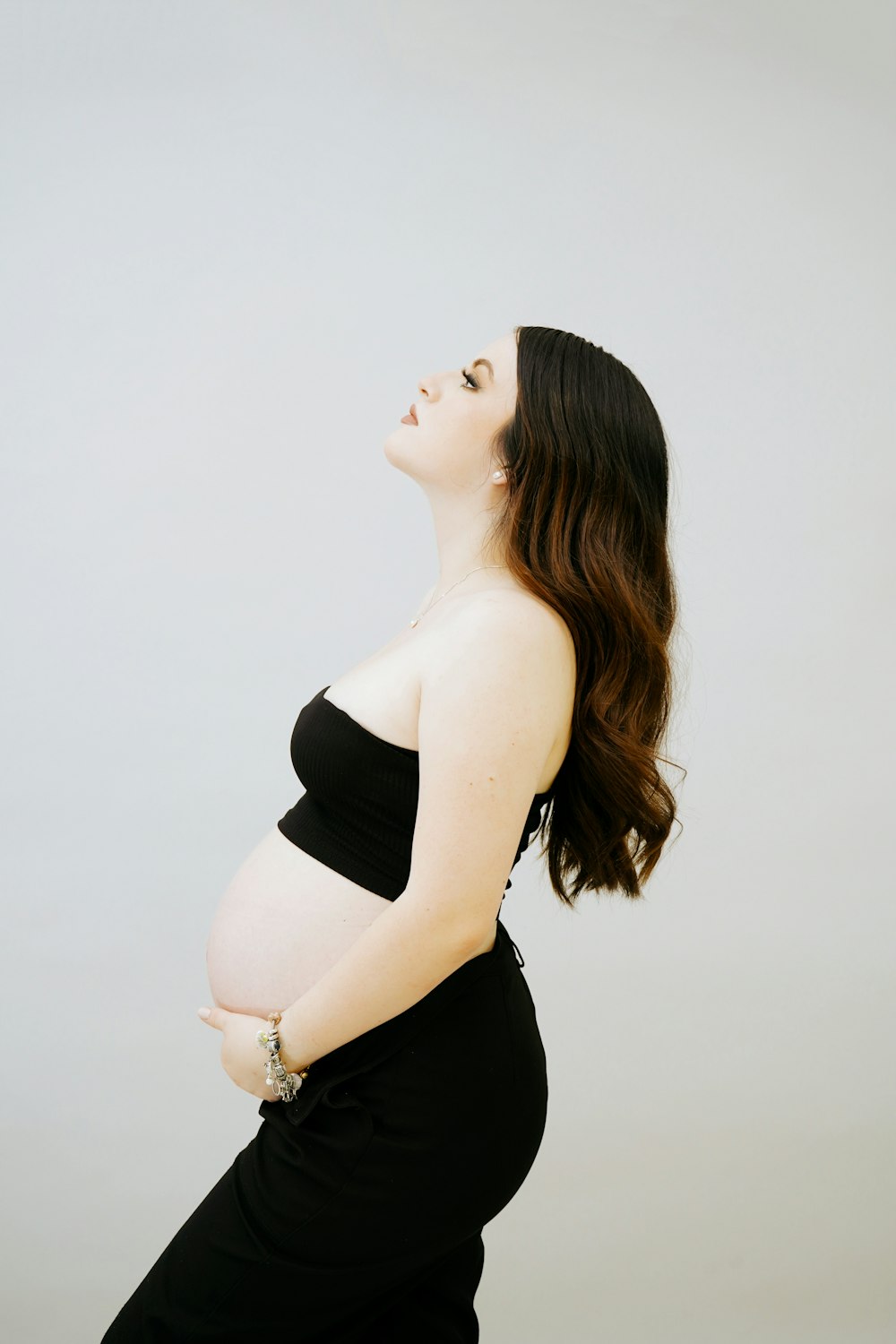 Une femme enceinte en robe noire pose pour une photo